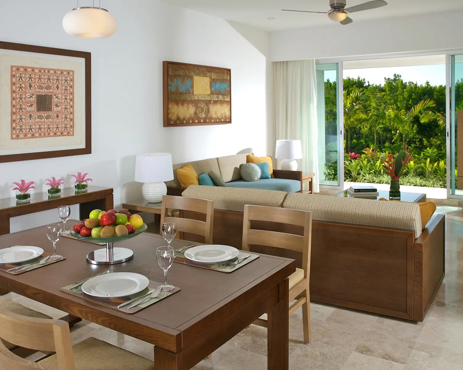 Living and dining area of a suite at The Bliss, Vidanta Riviera Maya, featuring tropical decor and garden views